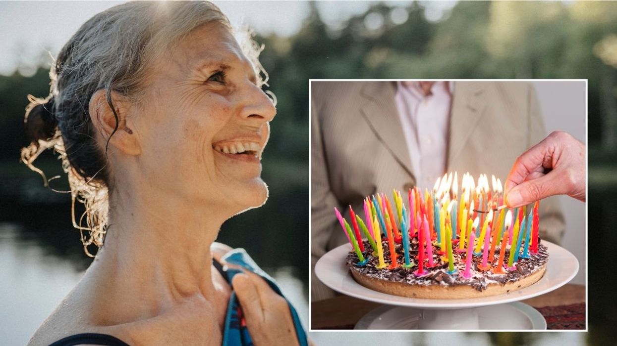 SENIOR WOMAN AND CAKE WITH CANDLES