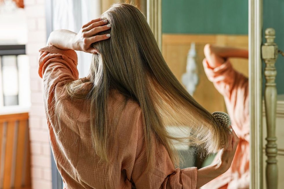 SENIOR WOMAN BRUSHING HAIR