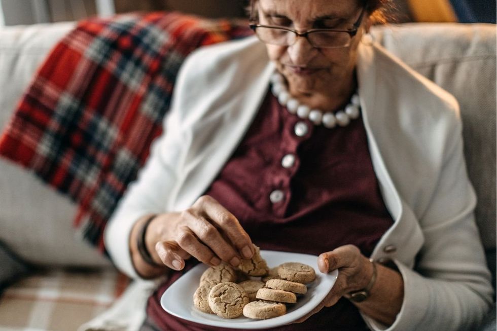 Senior woman eating cookie