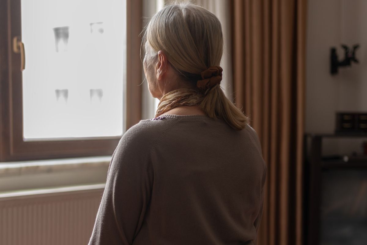SENIOR WOMAN STARING OUT OF WINDOW