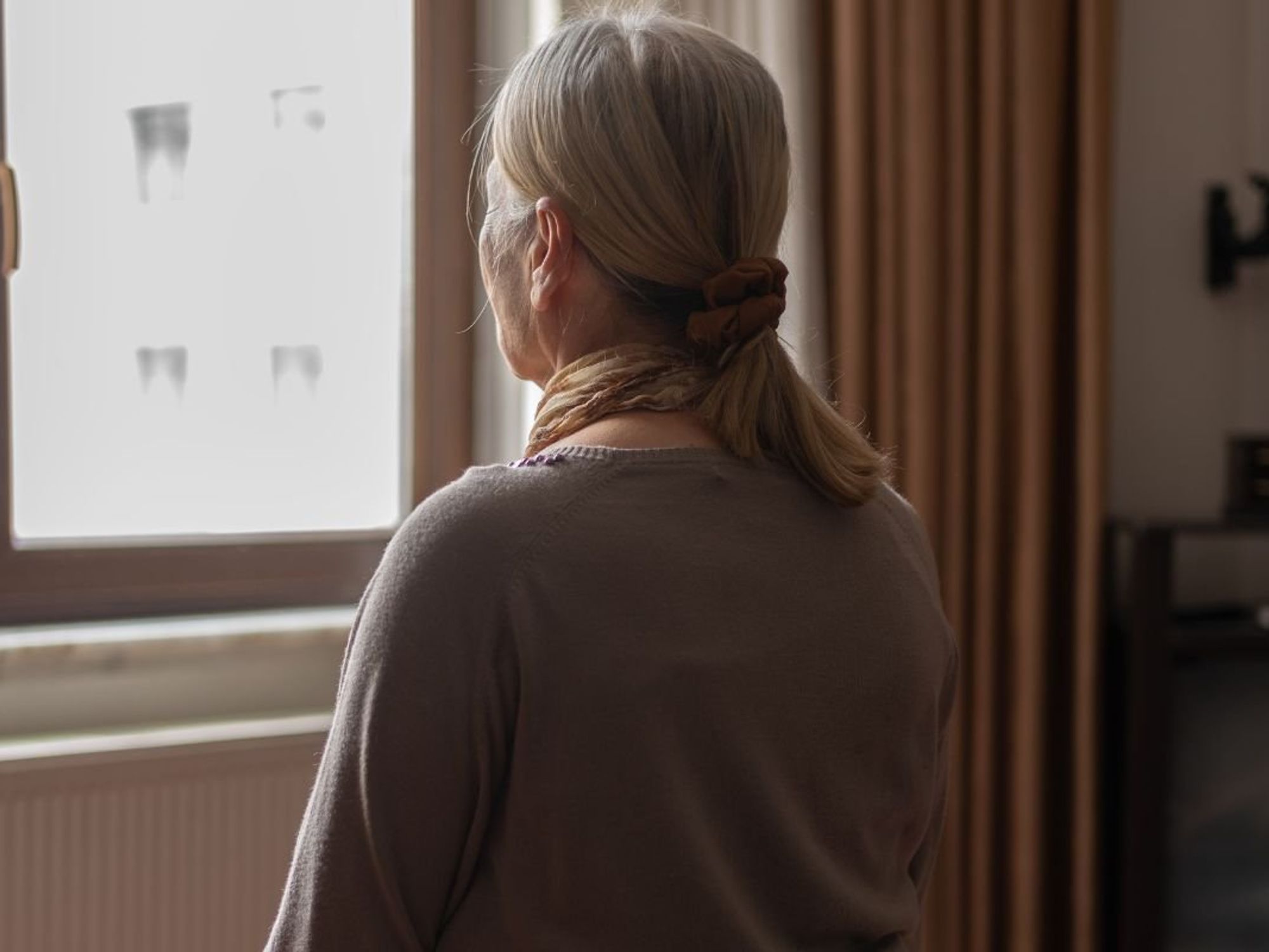 SENIOR WOMAN STARING OUT OF WINDOW
