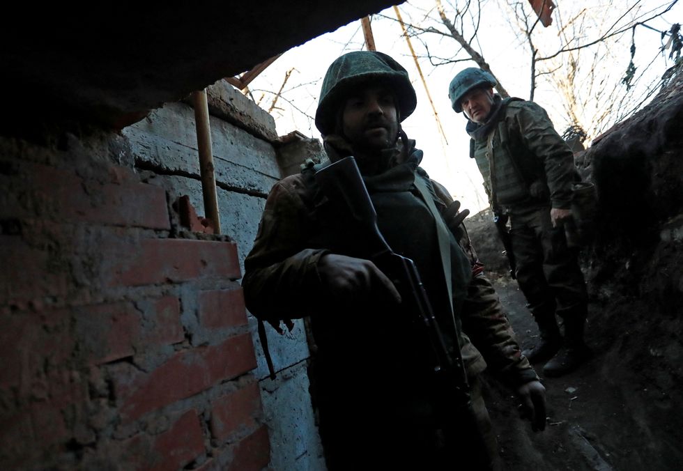 Service members of pro-Russian troops are seen outside a building, which according to the military, was previously a fighting position of Ukrainian armed forces, during Ukraine-Russia conflict in the town of Marinka, in the Donetsk Region, Ukraine March 22, 2022. REUTERS/Alexander Ermochenko\u2028