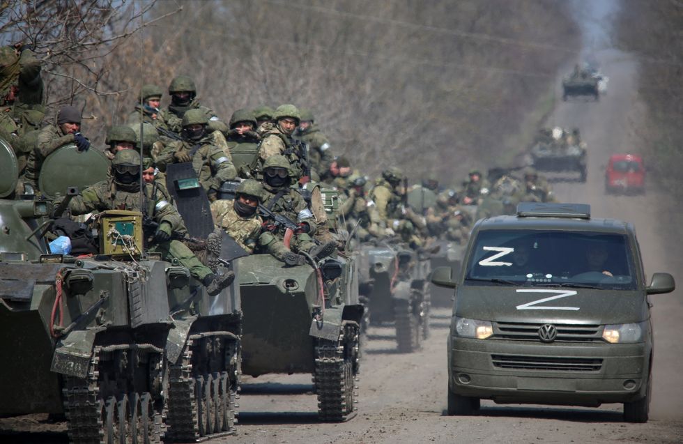 Service members of pro-Russian troops ride on armoured vehicles in the course of Ukraine-Russia conflict on a road leading to the city of Mariupol.