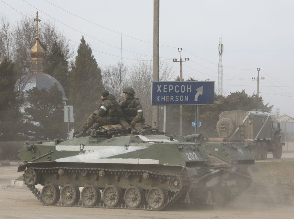 Servicemen ride on an armoured vehicle with the letter 'Z' on it, after Russian President Vladimir Putin authorized a military operation in eastern Ukraine, in the town of Armyansk, Crimea, February 24, 2022. REUTERS/Stringer