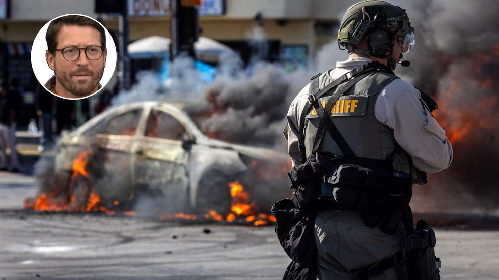 Sheriff at LA riots next to a burnt out car