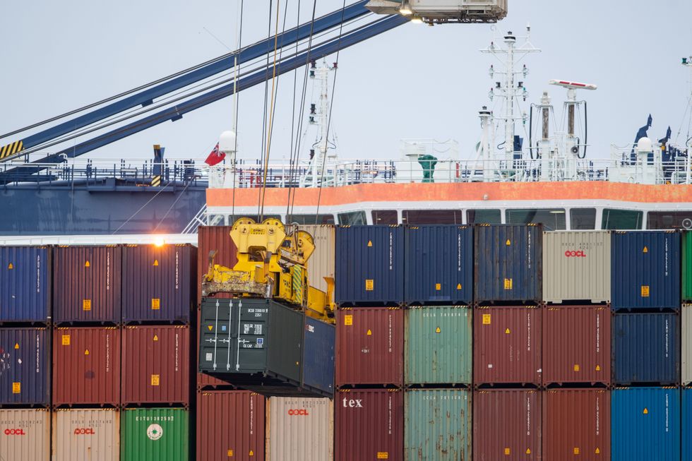 Shipping containers are unloaded from a cargo ship at the Port of Felixstowe in Suffolk. Shipments of personal protective equipment have been clogging UK ports, causing huge delays compounded by retailers and manufacturers importing goods for the Christmas shopping rush.