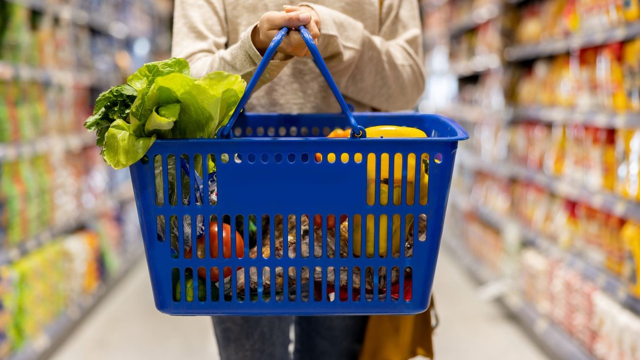 Shopper holding basket in supermarket