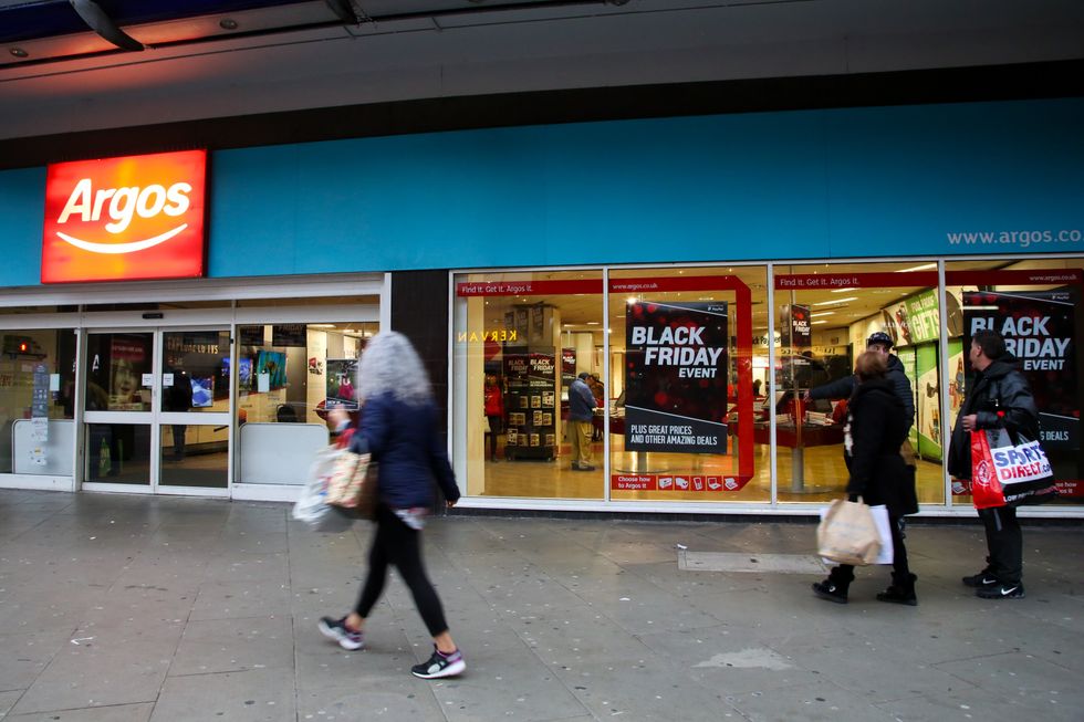 Shoppers are seen standing next to the Argos store in London as they prepare for Black Friday event with huge savings