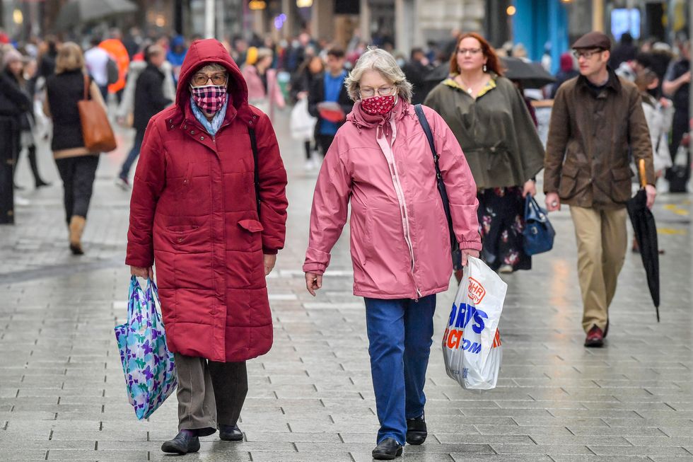 Shoppers wearing face masks carry bags in the centre of Cardiff.