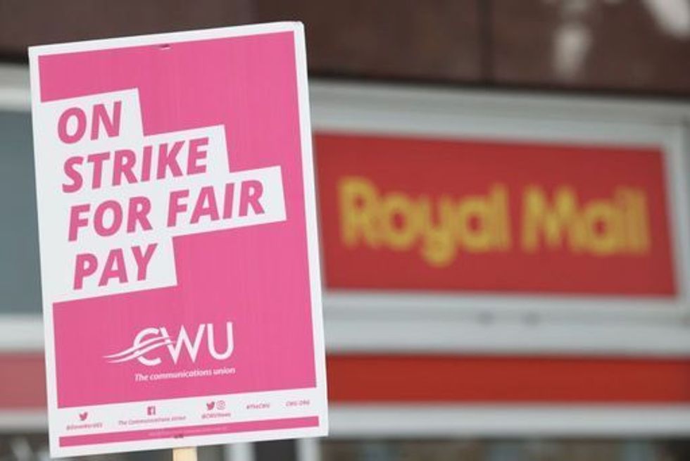sign held by a postal worker from the Communication Workers Union (CWU) on the picket line at the Royal Mail Whitechapel Delivery Office in east London