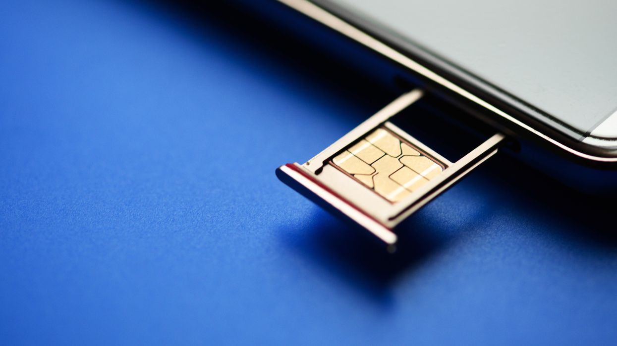 sim card tray retracted from a smartphone with a sim card sat in it