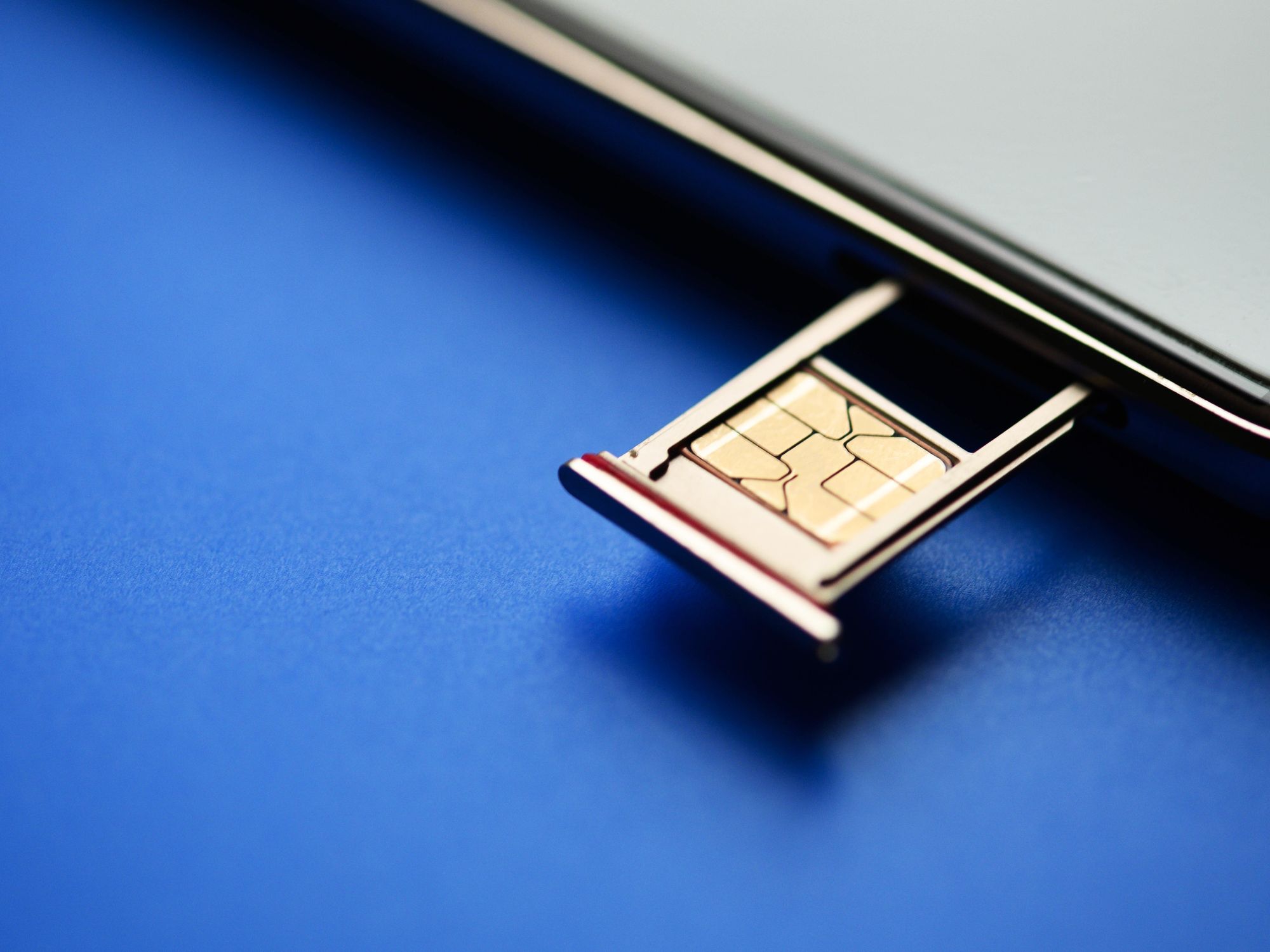 sim card tray retracted from a smartphone with a sim card sat in it