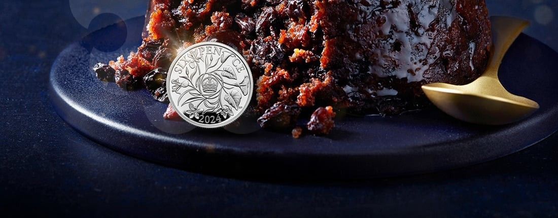 sixpence coin sat next to a Christmas pudding