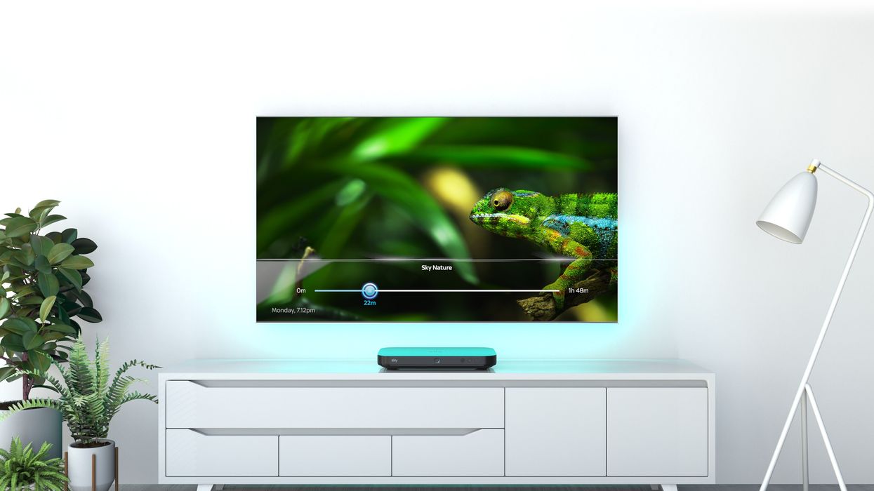 sky q box pictured on a white piece of furniture plugged into a flatscreen tv