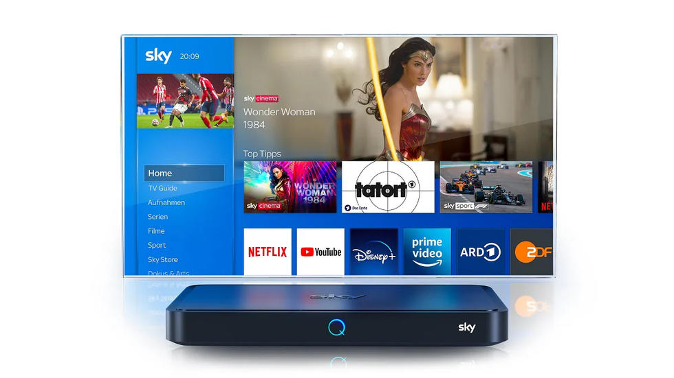 sky q pictured with a flatscreen tv behind it with a preview of the homescreen