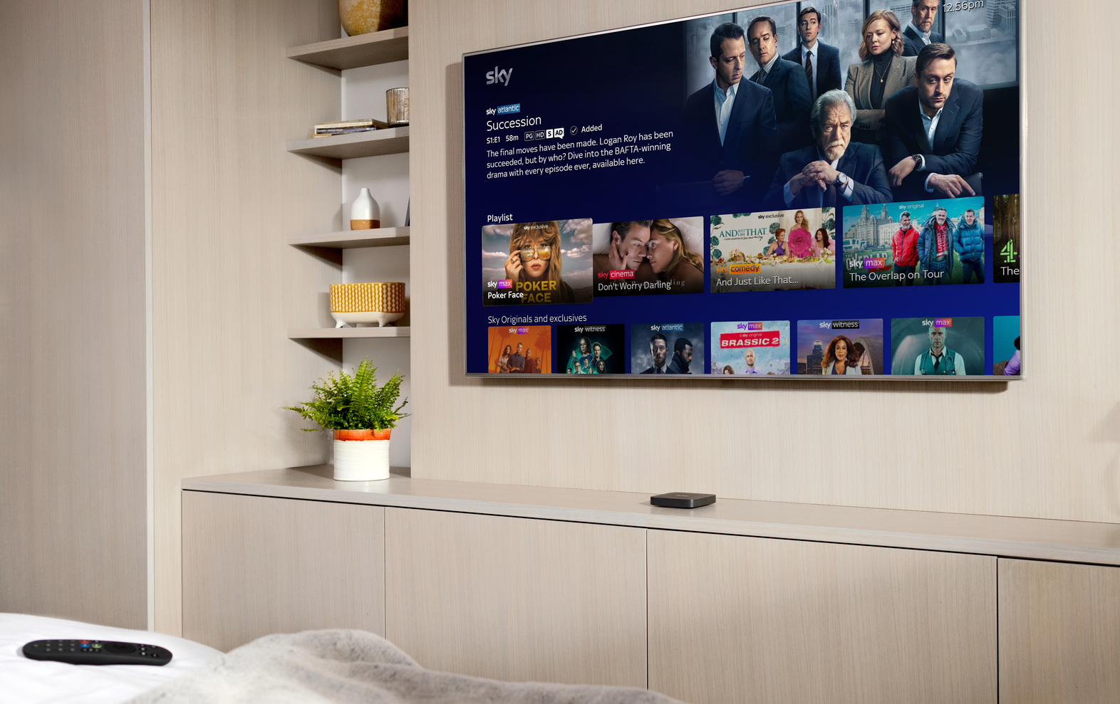 sky stream box in a bedroom with the remote on a bed