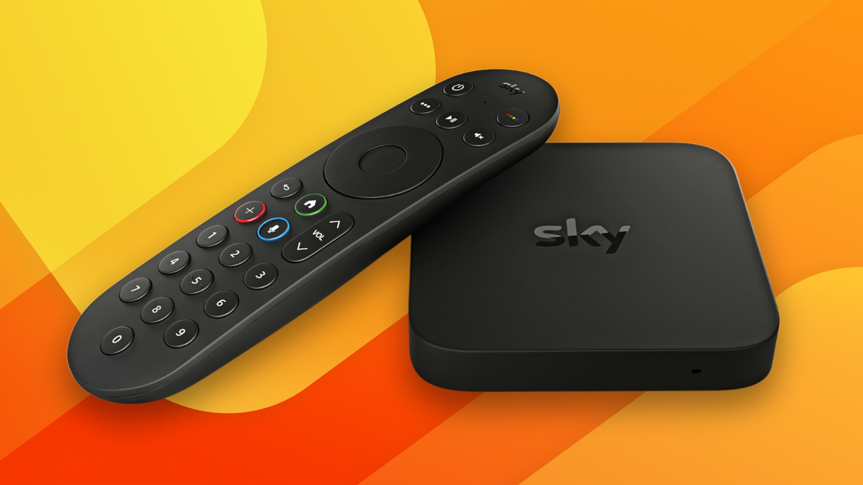 sky stream box with remote control lying next to it with a colourful background behind both