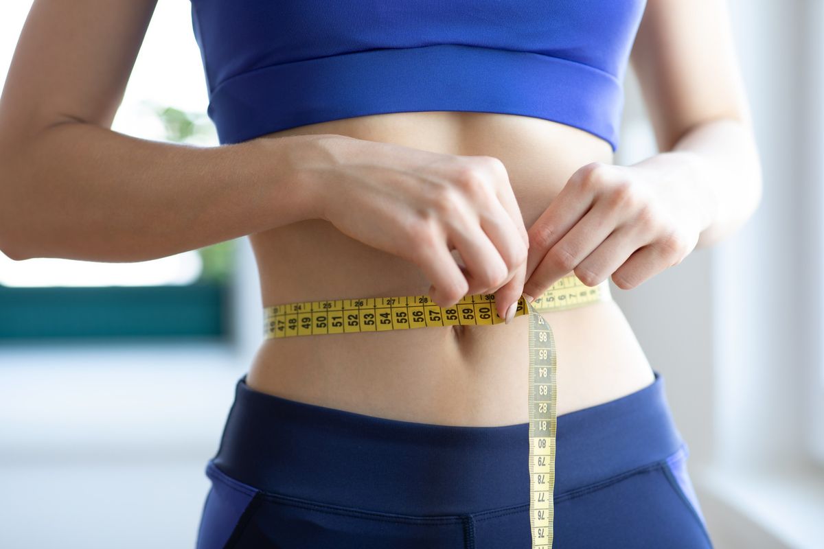 Slim woman measuring her waist