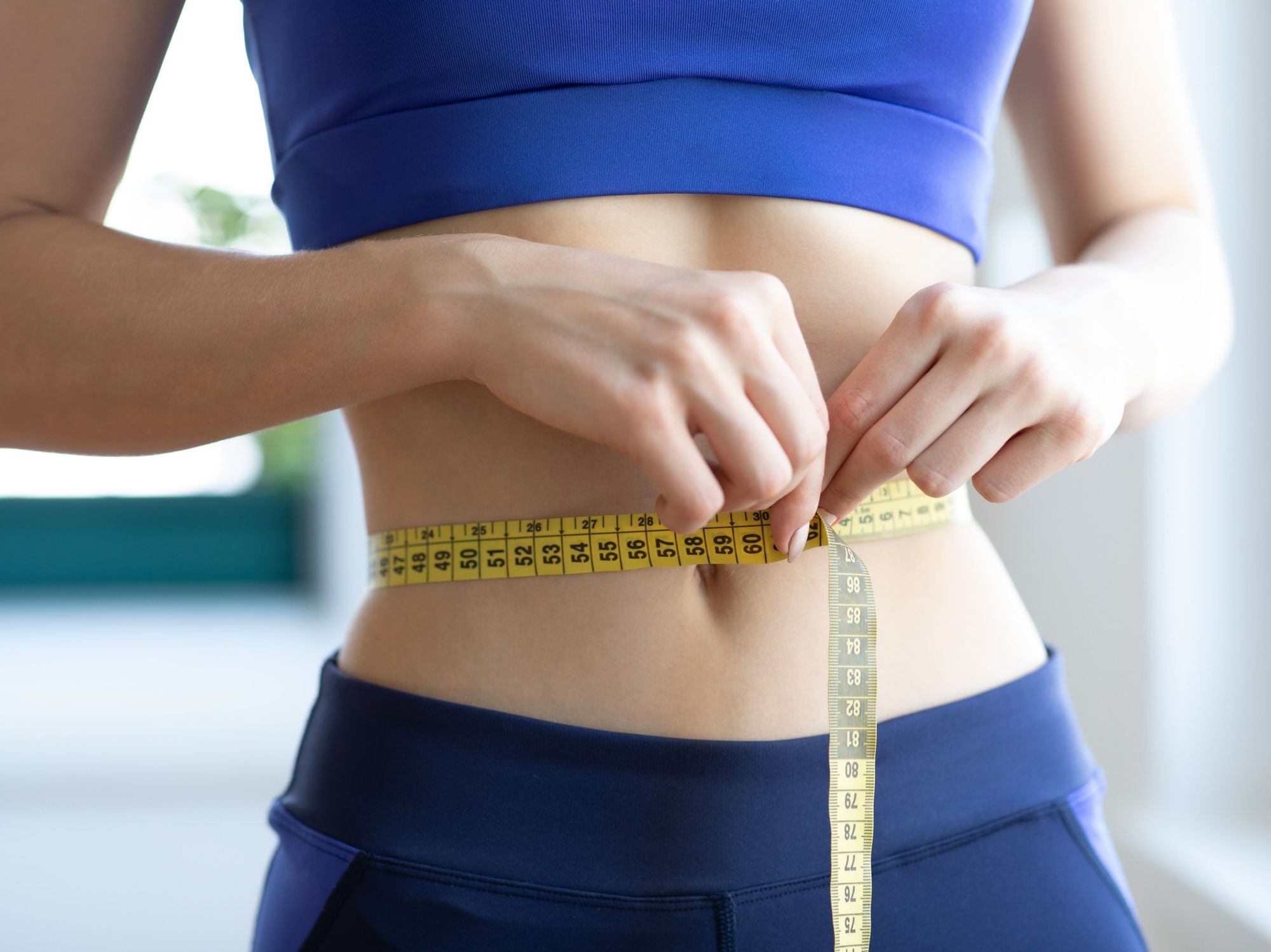 Slim woman measuring her waist