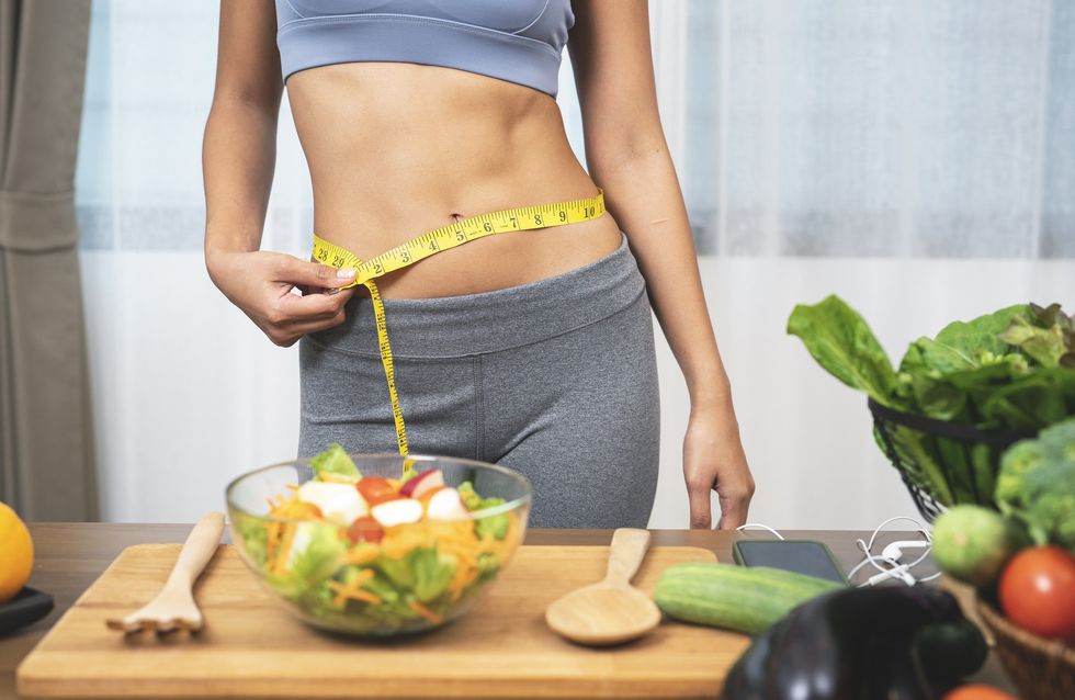 Slim woman measuring waist / Bowl of salad with leafy greens