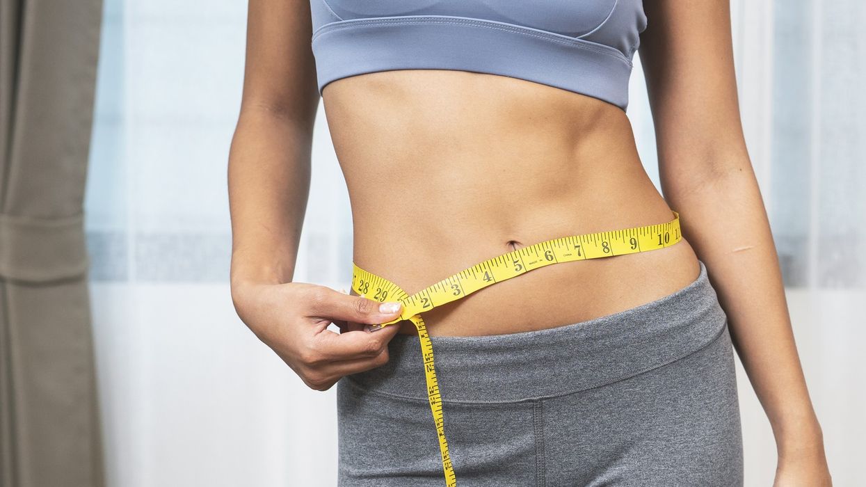 Slim woman measuring waist