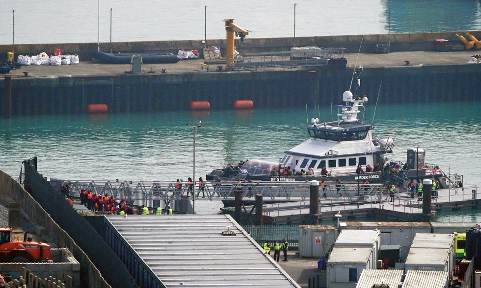 Small boat migrants boarding UK Border Force vessel