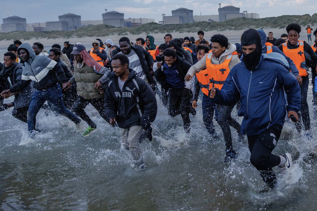 Small boat migrants charge on a French beach