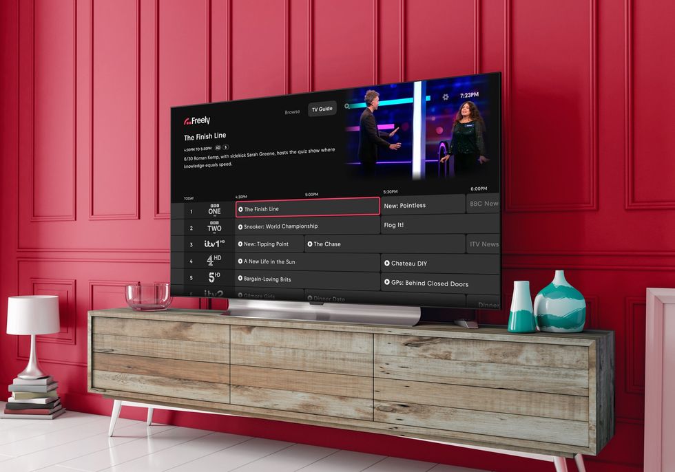 Smart TV in a living room with the Freely logo in the background with the Backwards TV Guide feature shown on-screen