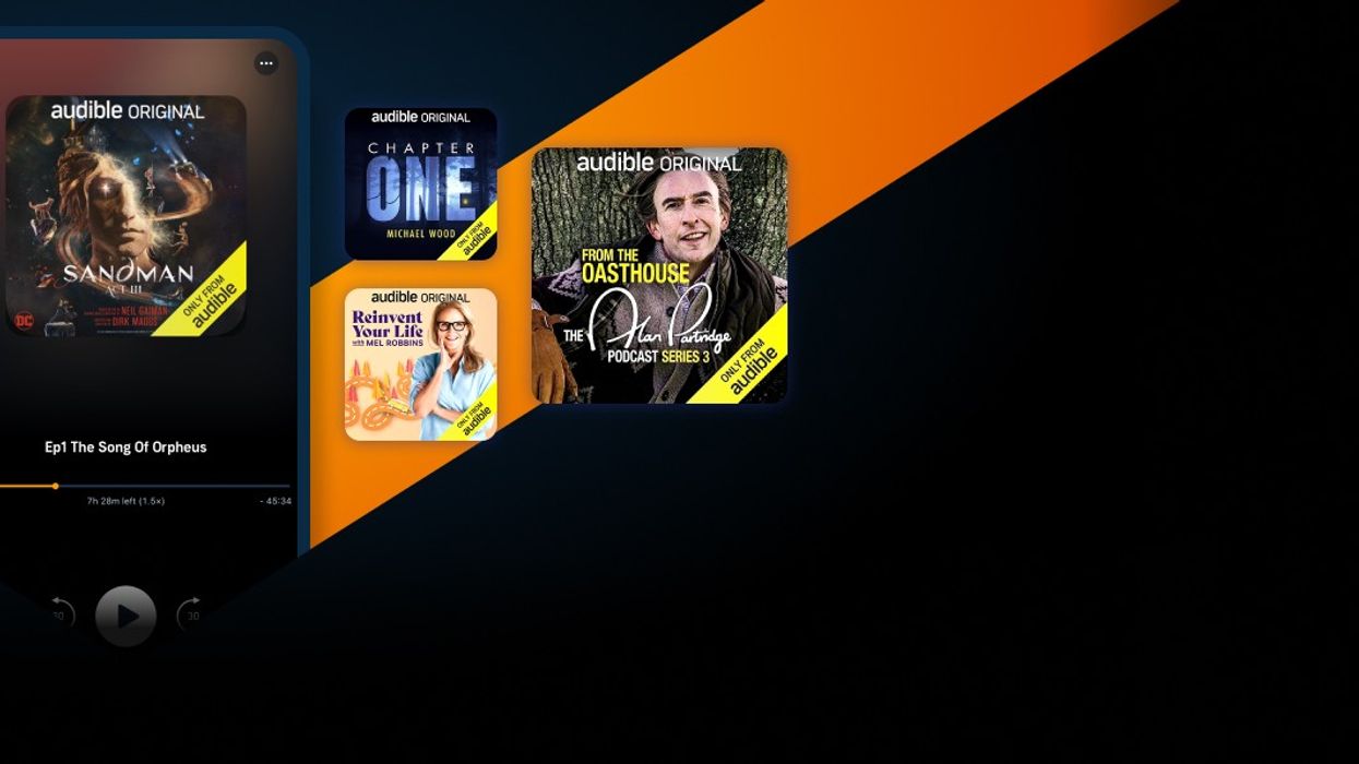 smartphone pictured with the audible app running on screen with preview artwork of other audible books and shows