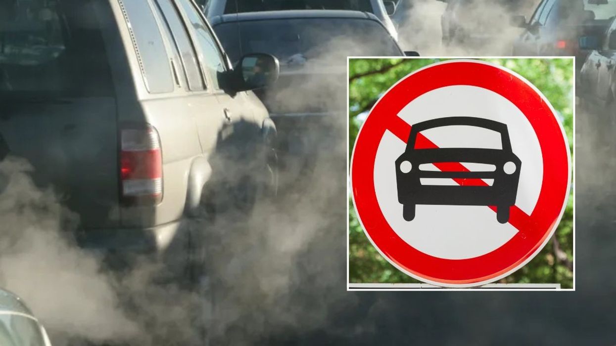 Smoke filled road and a car ban sign