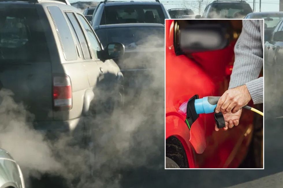 Smoke from vehicle exhausts and a man charging an electric car