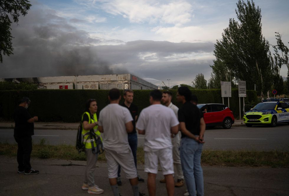 Smoke rises as firefighters work to extinguish a fire at a motorcycle production plant belonging to Japan's Honda, in Santa Perpetua de Mogoda, near Barcelona, Spain