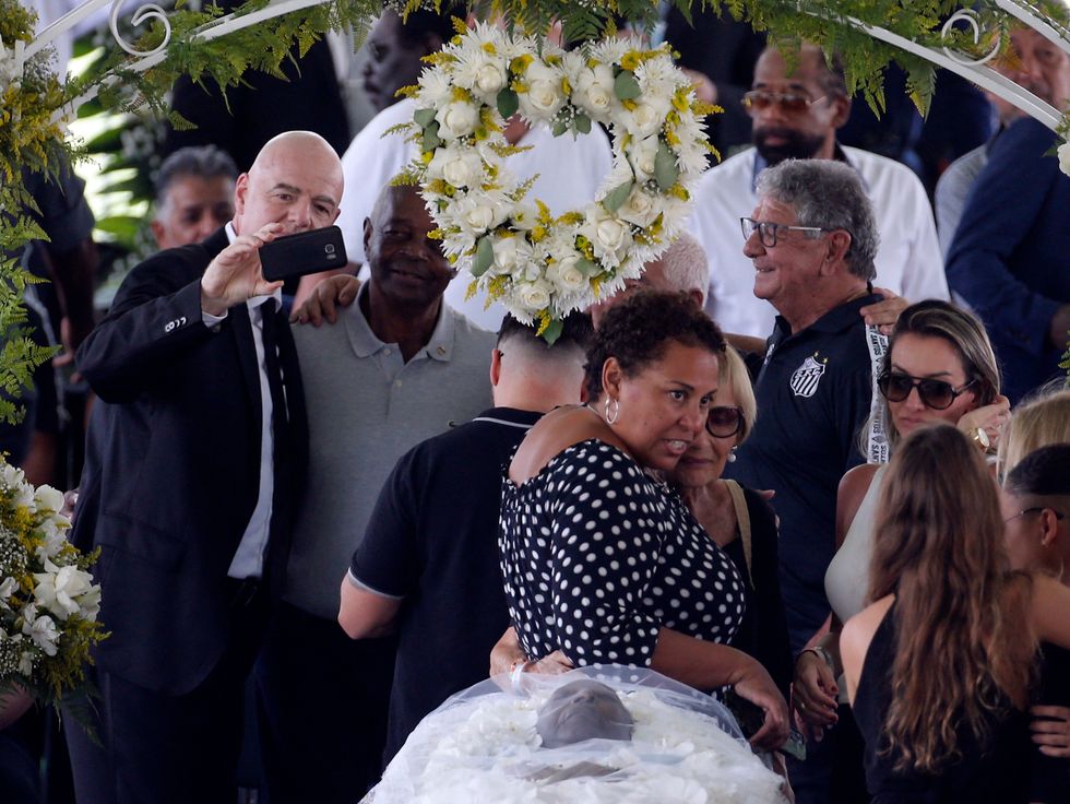 Soccer Football - Death of Brazilian soccer legend Pele - Vila Belmiro Stadium, Santos, Brazil - January 2, 2023 SENSITIVE MATERIAL. THIS IMAGE MAY OFFEND OR DISTURB FIFA president Gianni Infantino takes a selfie, and Pele's daughter, Kelly Cristina Nascimento is pictured with mourners as the body of Brazilian soccer legend Pele is seen in his casket, as he lays in state on the pitch of his former club Santos' Vila Belmiro stadium REUTERS/Diego Vara