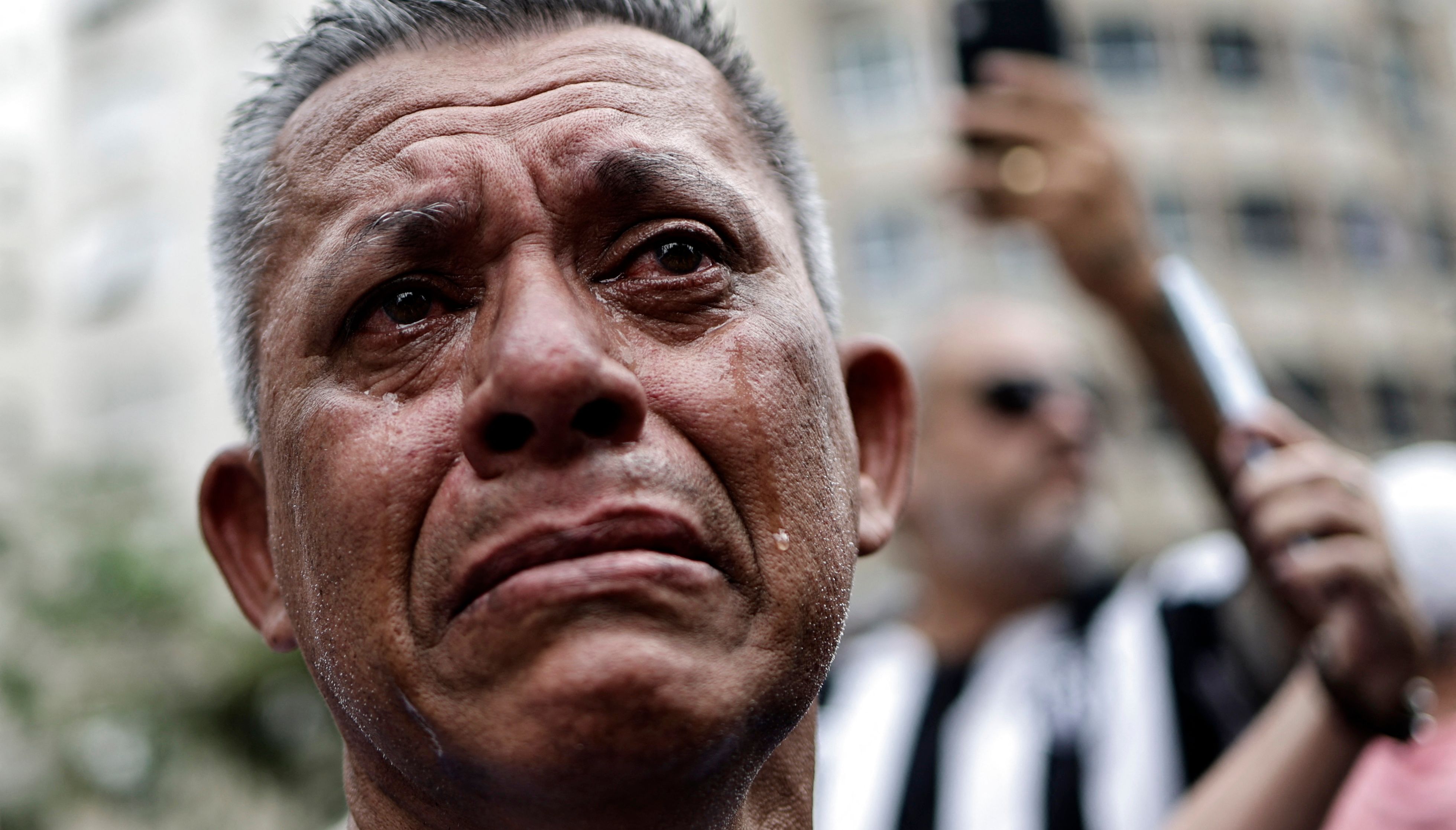 Soccer Football - Death of Brazilian soccer legend Pele - Vila Belmiro Stadium, Santos, Brazil - January 3, 2023 A mourner reacts as Brazilian soccer legend Pele is transported by the fire department, from his former club Santos' Vila Belmiro stadium REUTERS/Ueslei Marcelino