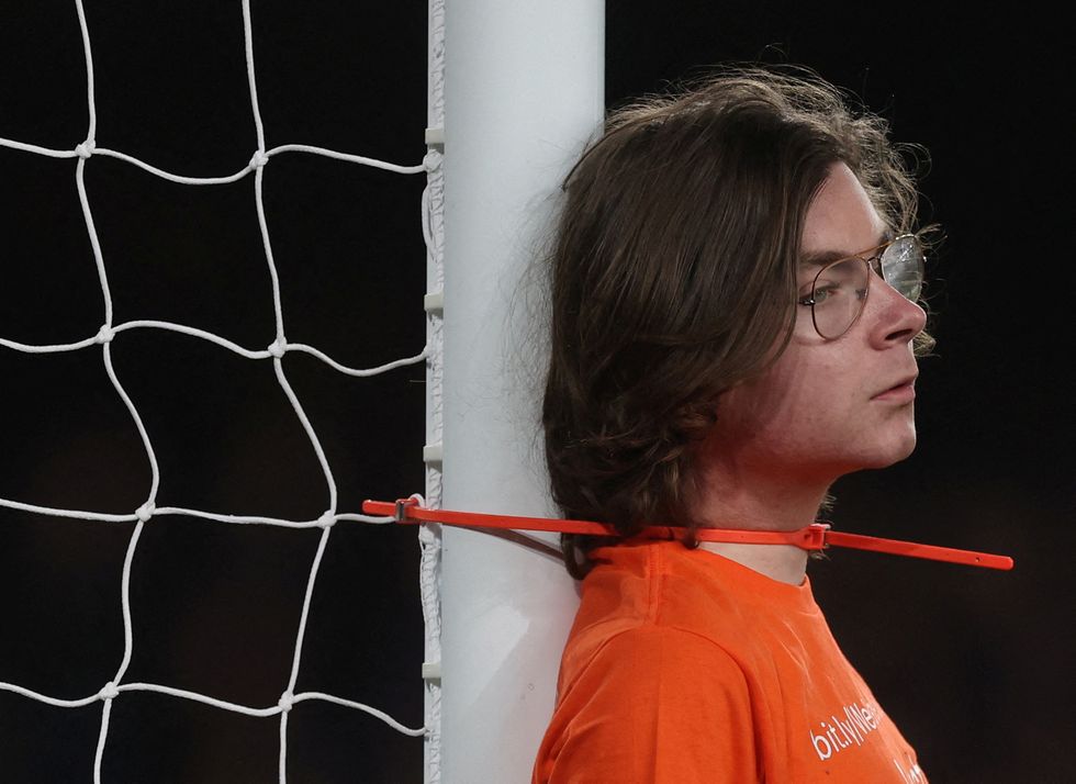 Soccer Football - Premier League - Everton v Newcastle United - Goodison Park, Liverpool, Britain - March 17, 2022 A protester ties himself to a goalpost during the match Action Images via Reuters/Lee Smith EDITORIAL USE ONLY. No use with unauthorized audio, video, data, fixture lists, club/league logos or 'live' services. Online in-match use limited to 75 images, no video emulation. No use in betting, games or single club /league/player publications.  Please contact your account representative for further details.     TPX IMAGES OF THE DAY