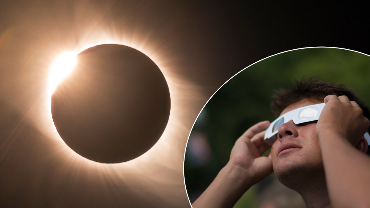 Solar eclipse/man observing it with glasses
