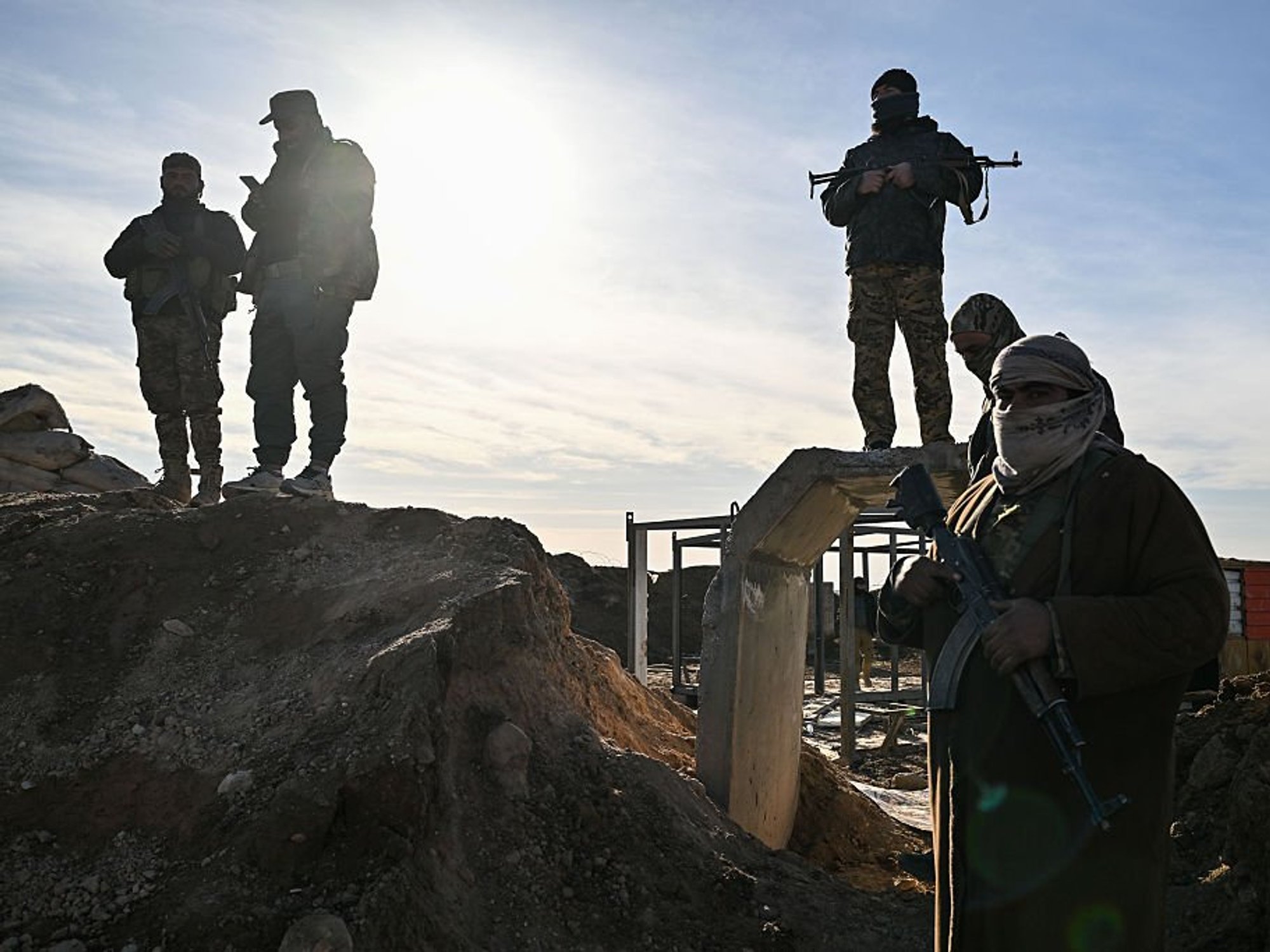 Soldiers of Syrian government forces stand by on a position 10 km away from the city of Hasakah in northeastern Syria