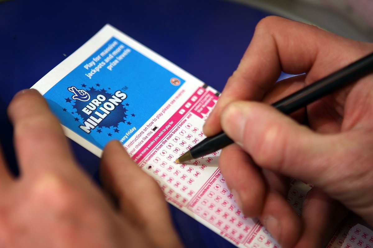 Somebody putting numbers down on a Euromillions ticket
