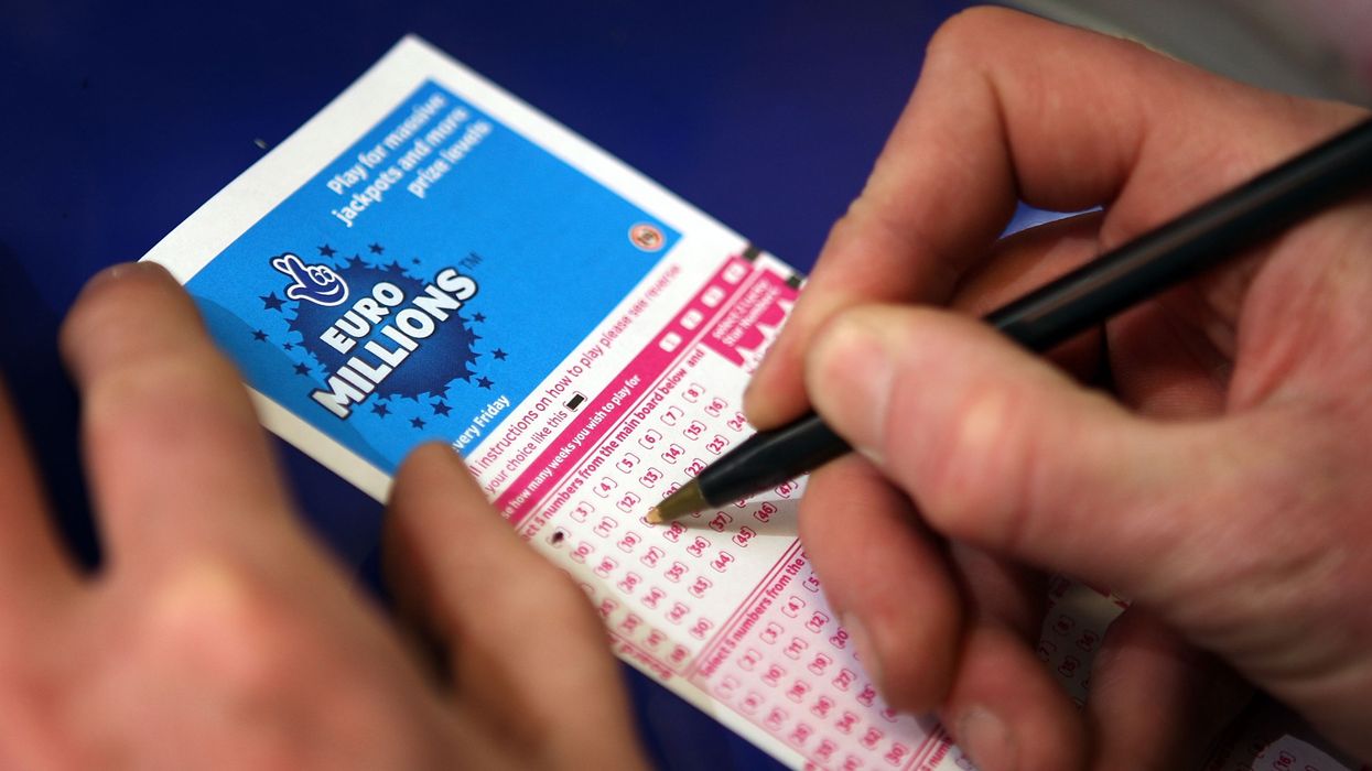 Somebody putting numbers down on a Euromillions ticket