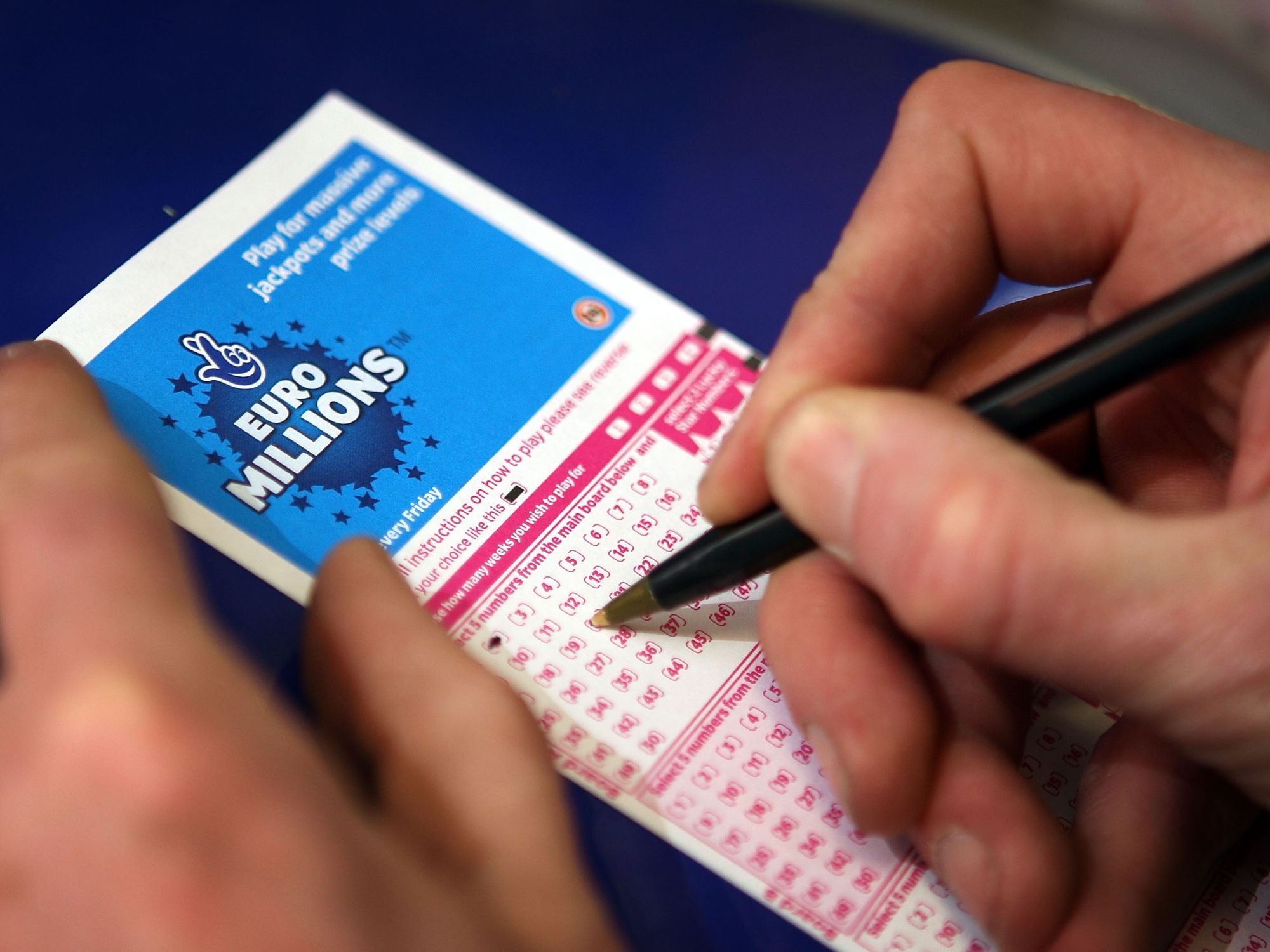 Somebody putting numbers down on a Euromillions ticket