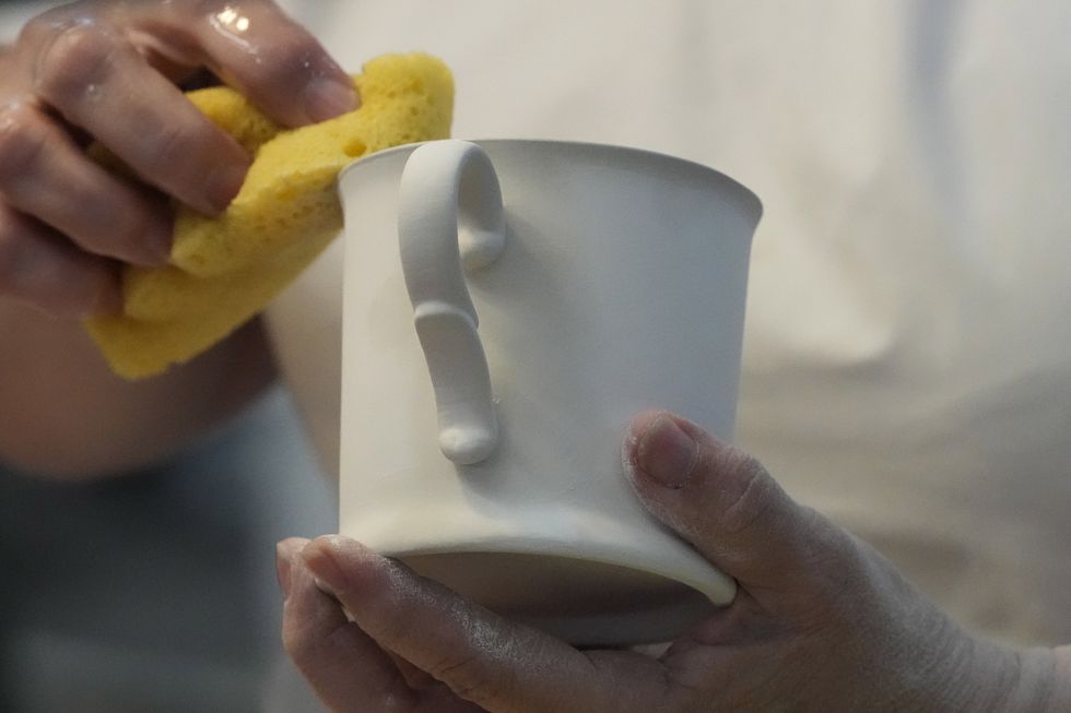 Someone cleaning a ceramic mug