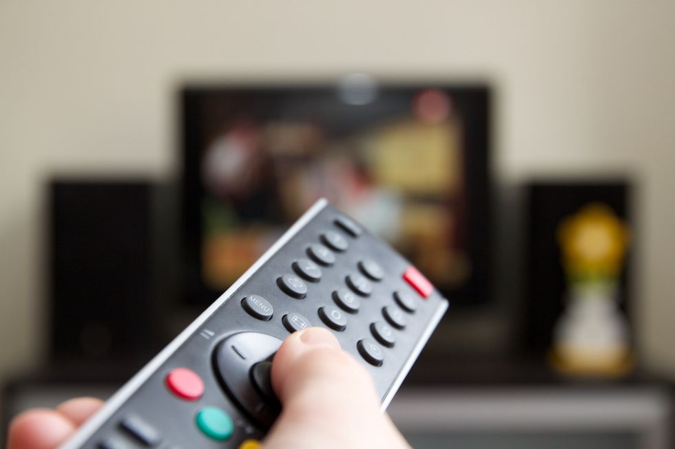 Someone pointing a remote at a TV