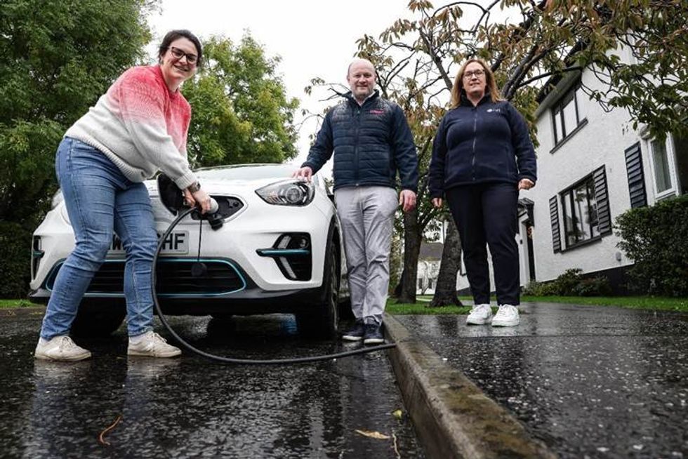 Sorcha (L) is the first resident in Northern Ireland to receive a cross-pavement channel. The installation was unveiled by Emma Stockman, Head of Transport and Decarbonisation at the DfI (R), and Thomas O'Hagan (centre) from Kerbo Charge install partner Weev
