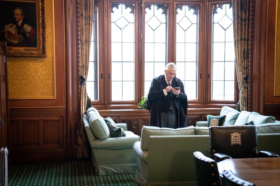 Speaker of the House of Commons Sir Lindsay Hoyle uses a mobile phone in his office in the Palace of Westminster, London. Picture date: Monday February 21, 2022.