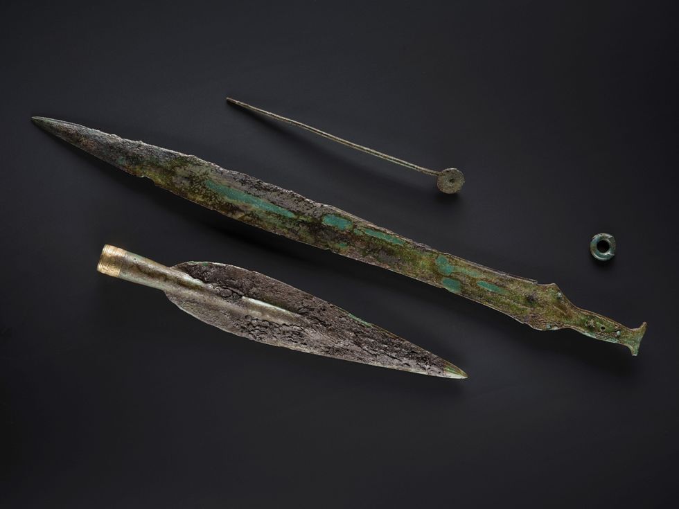 Spearhead decorated with gold, and a bronze sword in a wooden scabbard