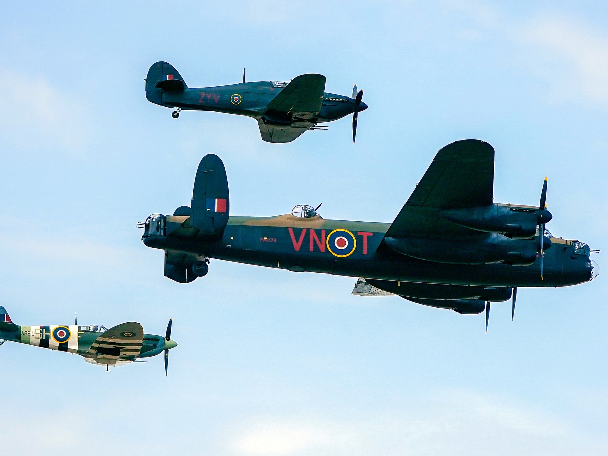 Spitfire, a Hawker Hurricane, and a Lancaster bomber, part of the Battle of Britain Memorial Flight, during the annual Southport Air Show at Southport beach in Merseyside