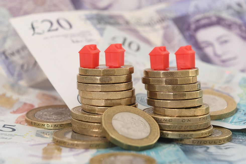 Stack of coins with small houses on top