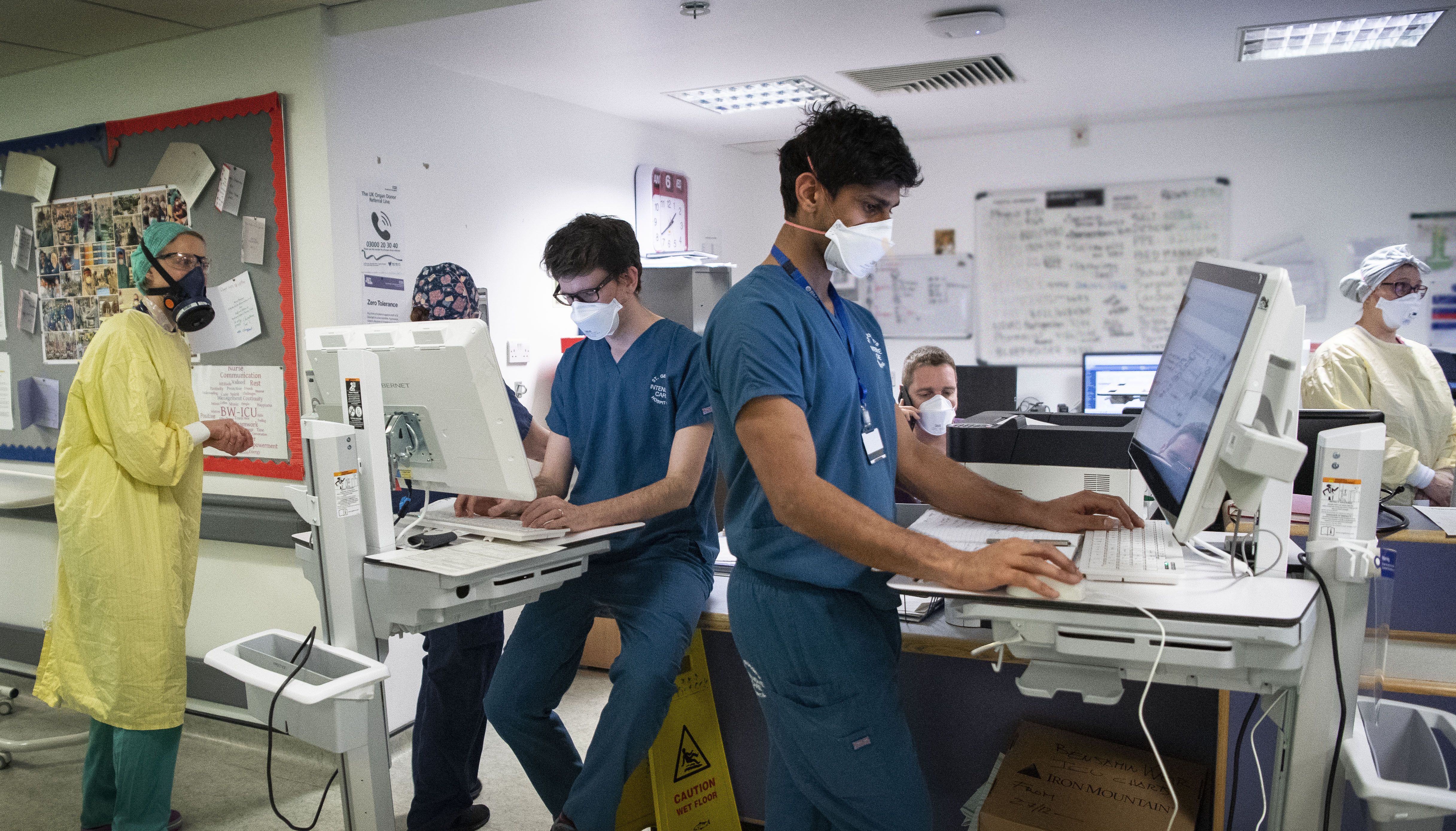 Staff members work at a desk in the ICU (Intensive Care Unit) in St George's Hospital in Tooting, south-west London, where the number of intensive care beds for the critically sick has had to be increased from 60 to 120, the vast majority of which are for coronavirus patients.