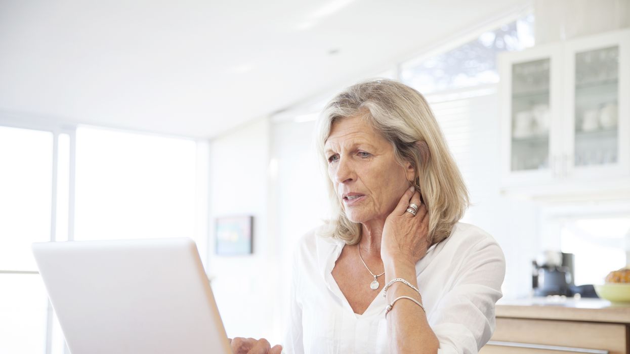 State pensioner looks worried while looking at laptop