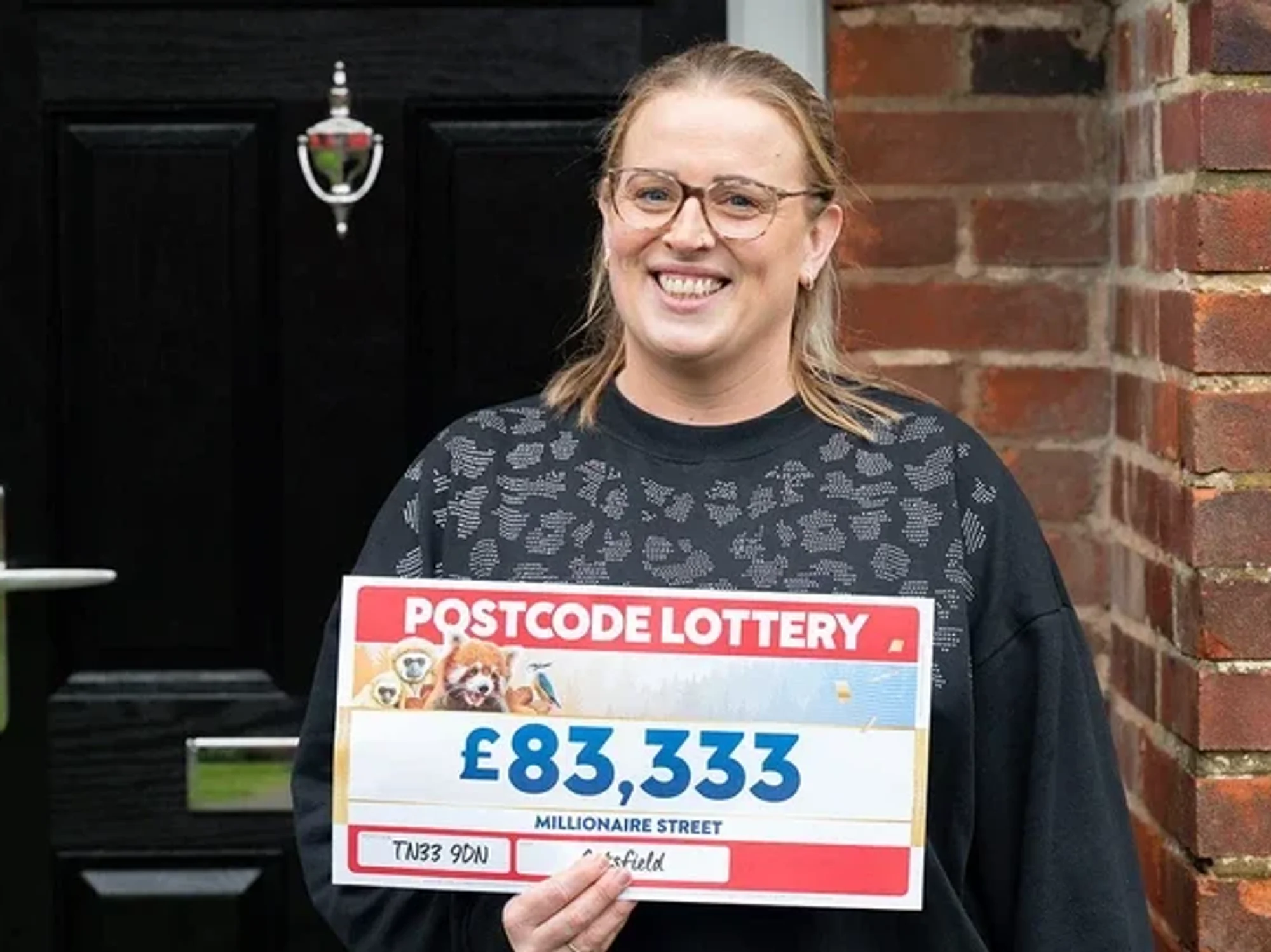 Steph Godfrey holding postcode lottery cheque